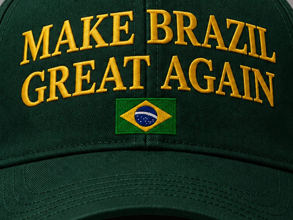 Detalhe do bordado MAKE BRAZIL GREAT AGAIN em amarelo sobre o boné verde, com a bandeira do Brasil